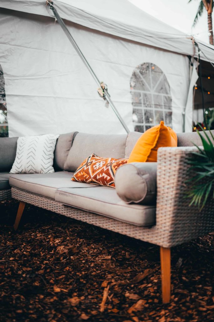 Boho couch next to a tent at a wedding reception