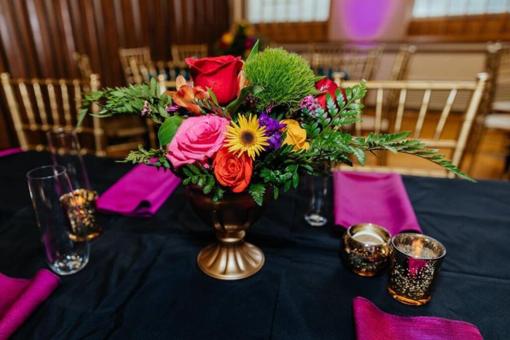 Colorful wedding flowers on a reception table with hot pink napkins at a wedding in Denver