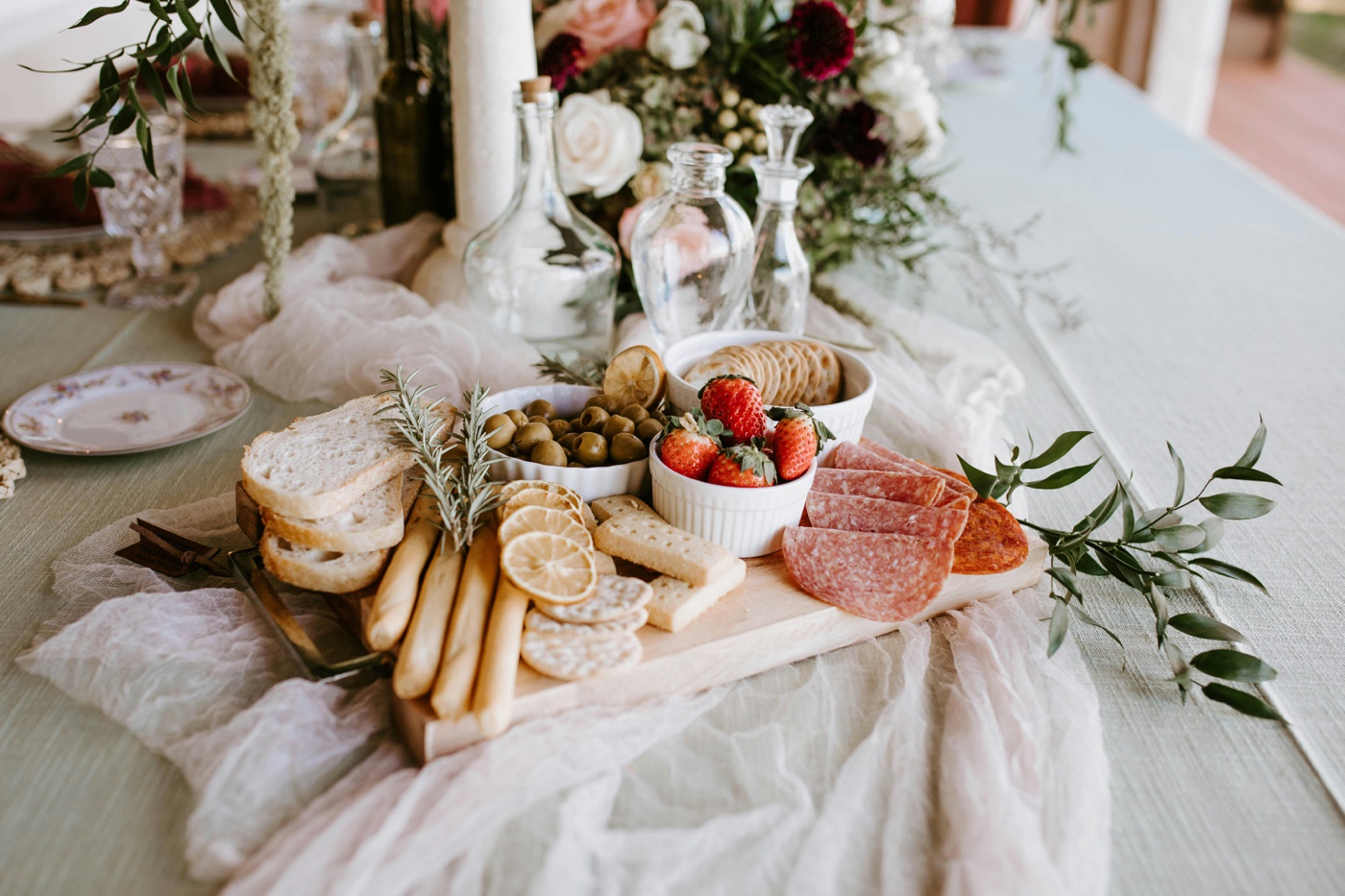A brunch charcuterie board with salami, strawberries, crackers, and bread at a Sunday wedding