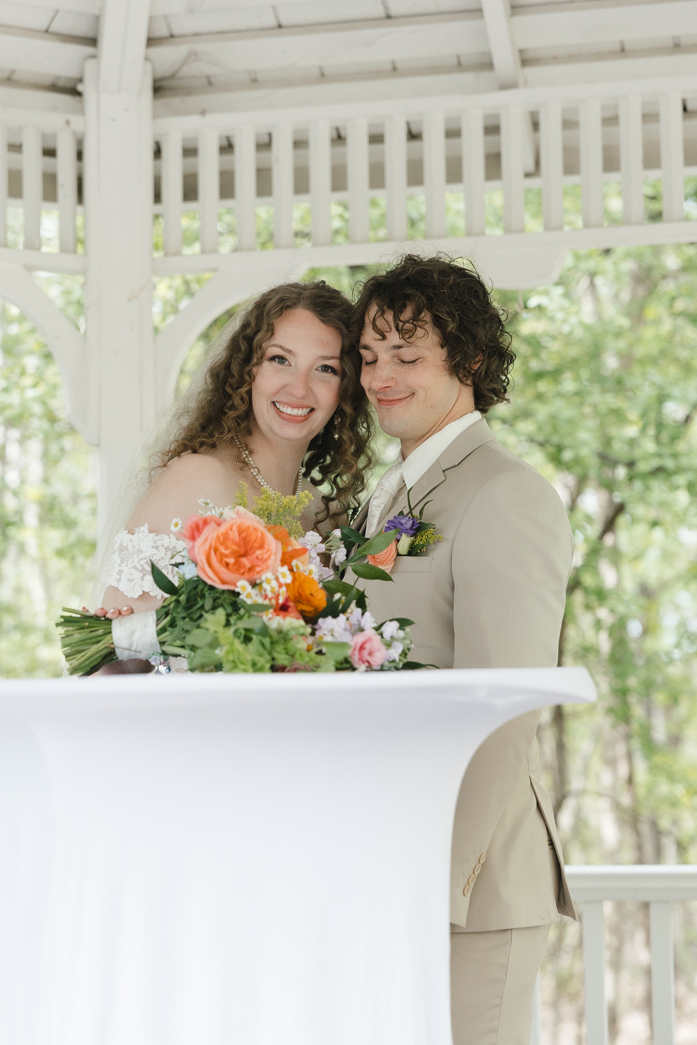 Bride and groom posing for a portrait in a gazebo