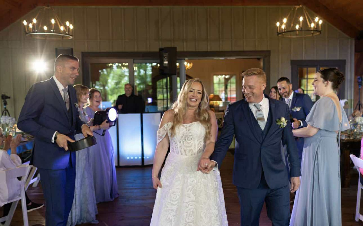Bride and groom entering their wedding reception at Forest Lodge Wedding & Retreat Center