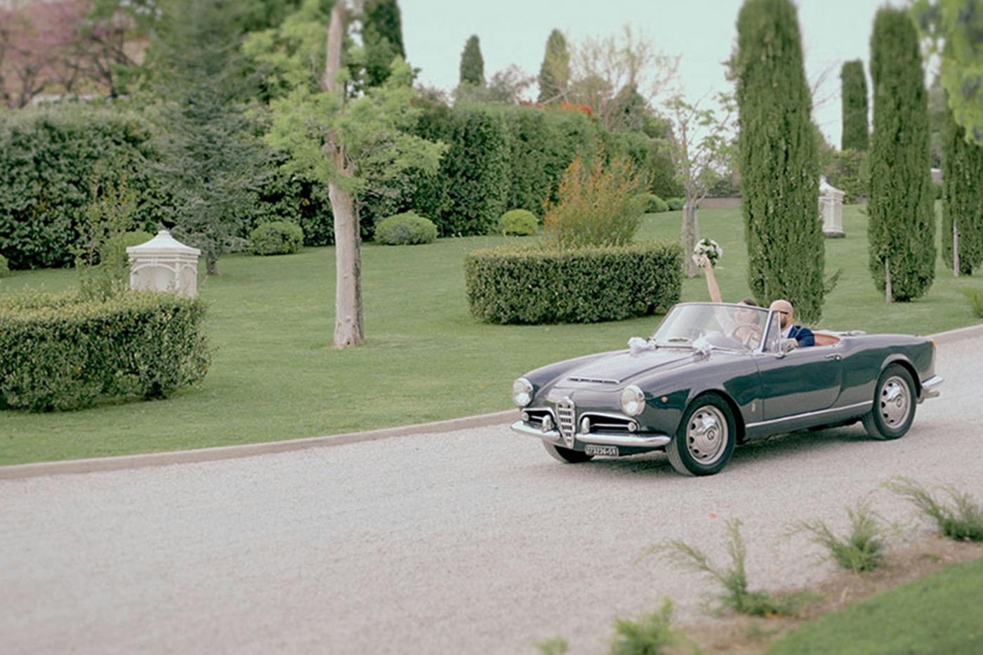 Bride and groom in a black vintage car